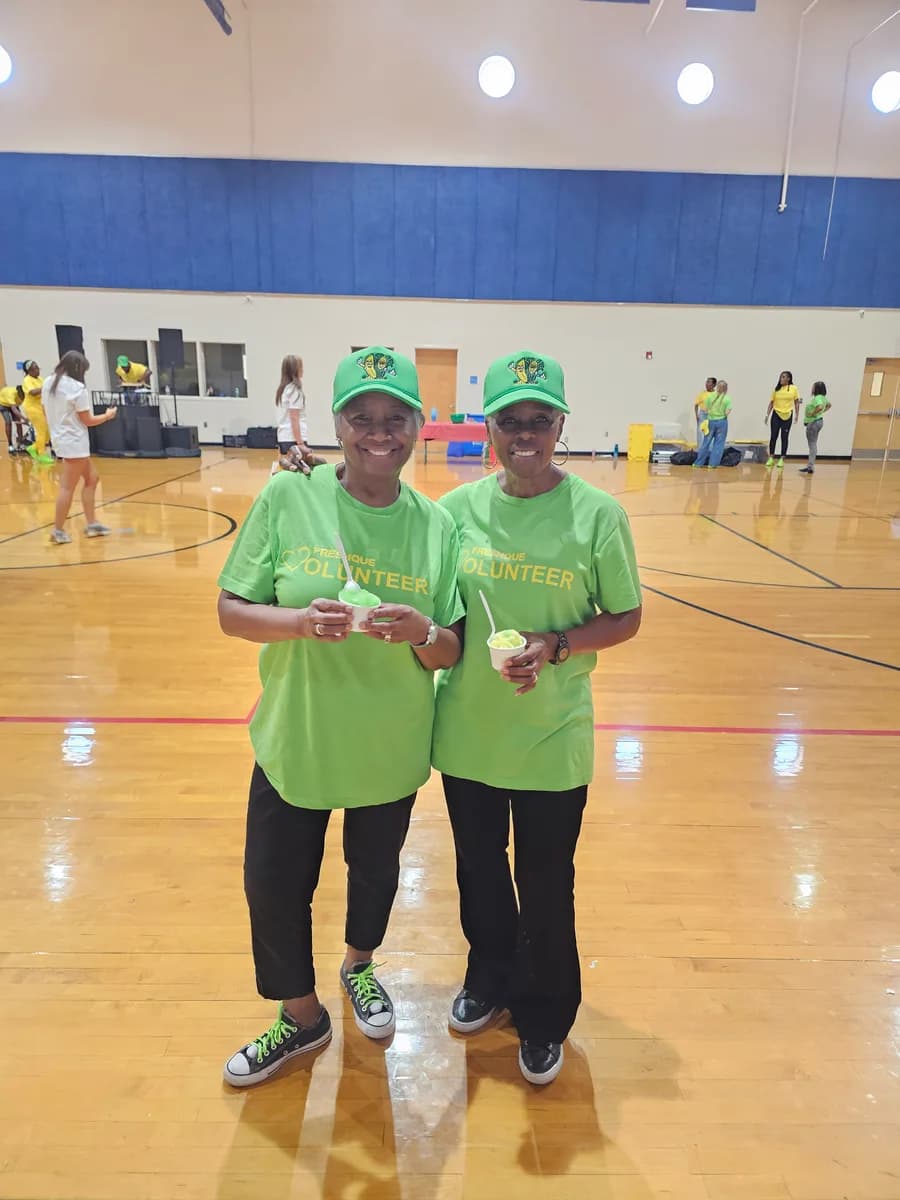 FreshQue volunteers holding Iced Out cups at a back-to-school resource event