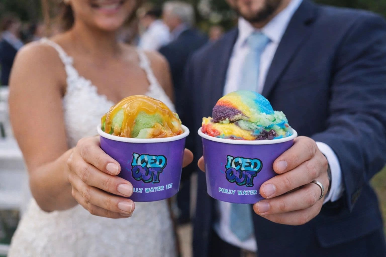 A couple in wedding attire holding colorful Iced Out water ice cups